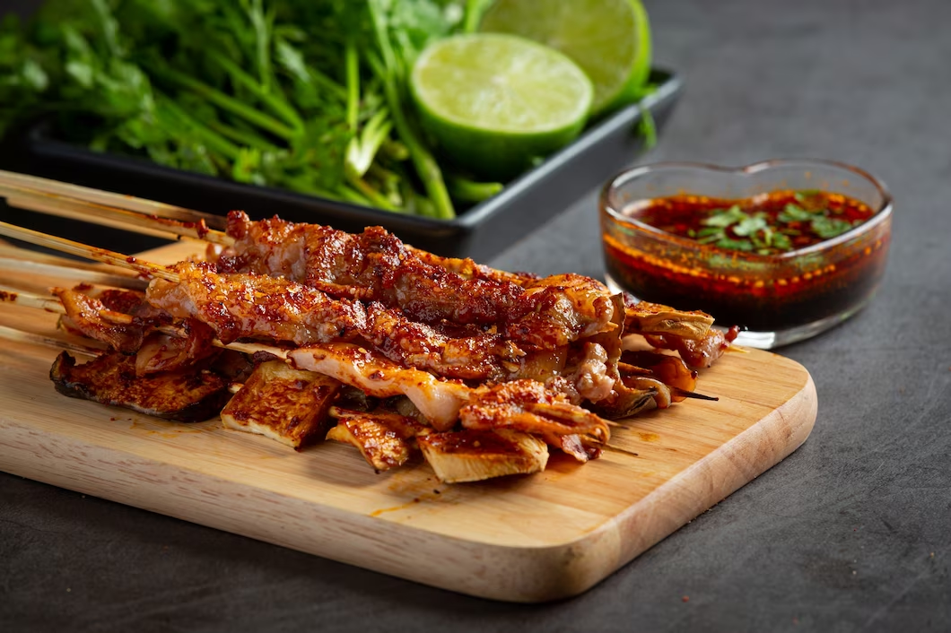 BBQ on a wooden board with sauce on the side