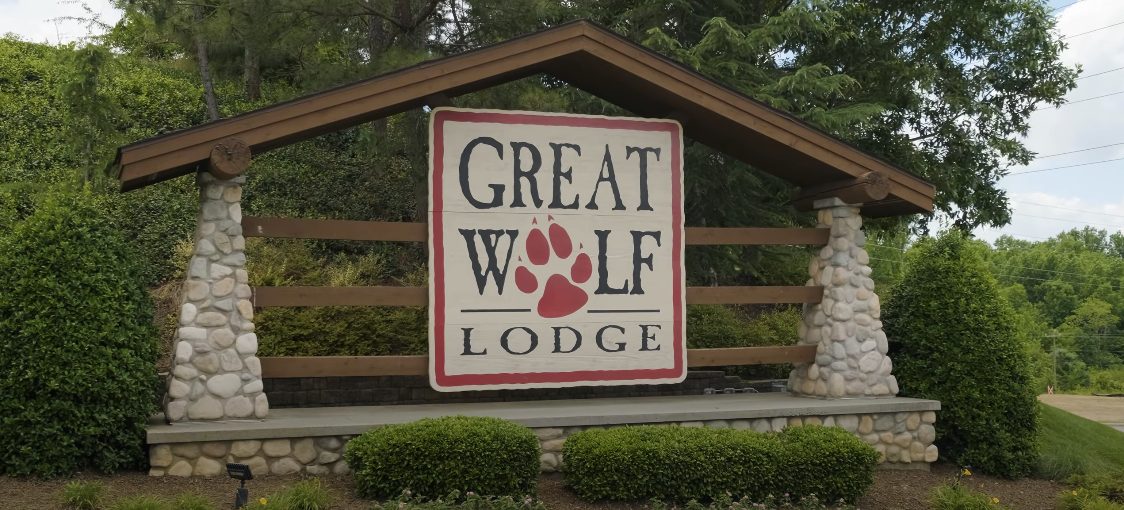 Shed with 'Great Wolf Lodge' sign and trees in the background